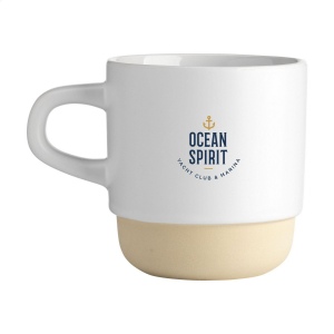 Mug empilable avec anse en céramique de haute qualité et 5% de céramique recyclée. La partie inférieure de la tasse n'est pas émaillée et montre la céramique naturelle non traitée. 5